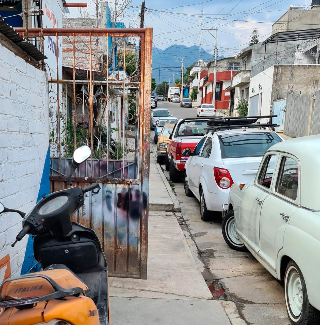 Incluso con las puertas de este taller de hojalatería se obstruye el paso en la banqueta.