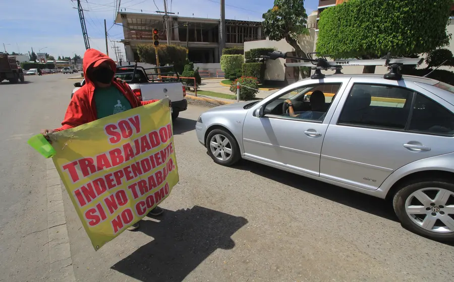 Persona con lona pidiendo trabajo en la calle