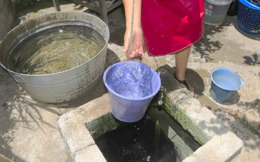 Mujer acarreando agua en cubeta