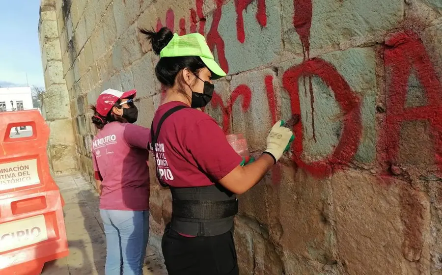 Personas limpiando grafitis