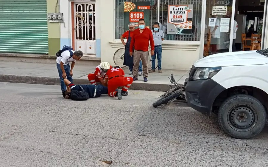 La motocicleta quedó tirada enfrente de la camioneta.