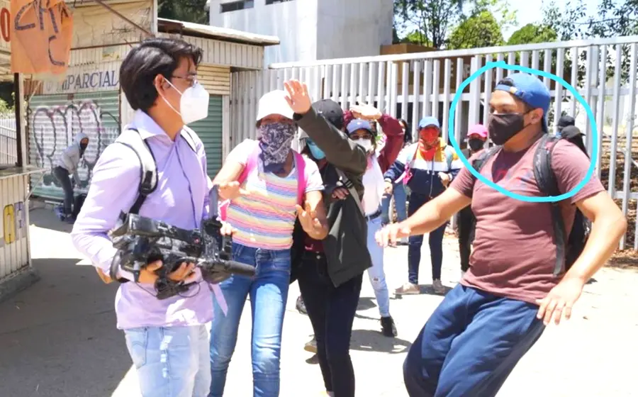 La persona señalada posa junto a diversas mercancías.