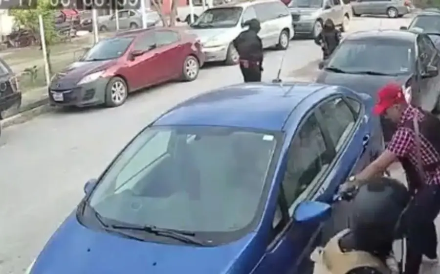 Un hombre y una mujer permanecen en la banqueta lamentando que los despojaron de un auto y no se percatan que delincuentes regresan y los amagan para que les entreguen las llaves de su segundo auto estacionado.