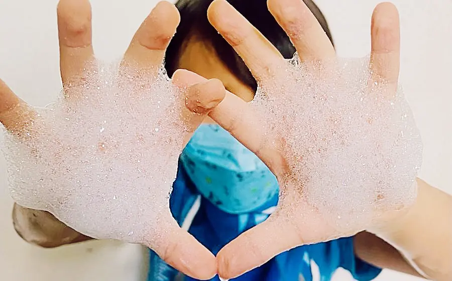 Niño con las manos lavadas con agua y jabón