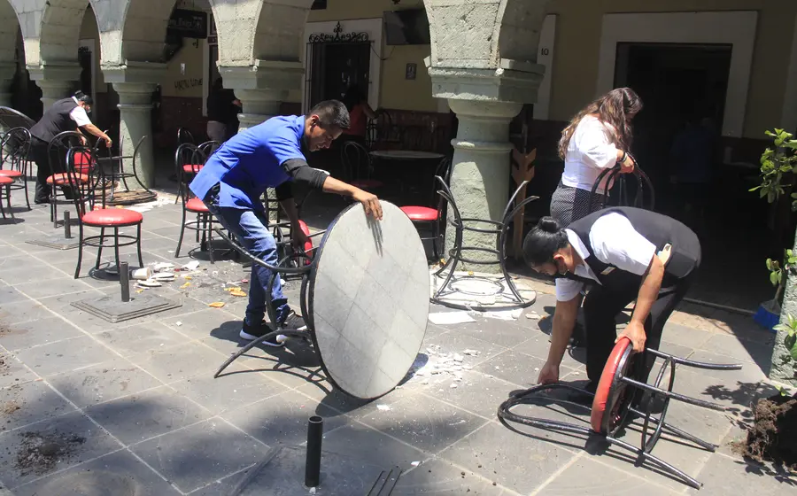 Jóvenes recogiendo mesa y sillas