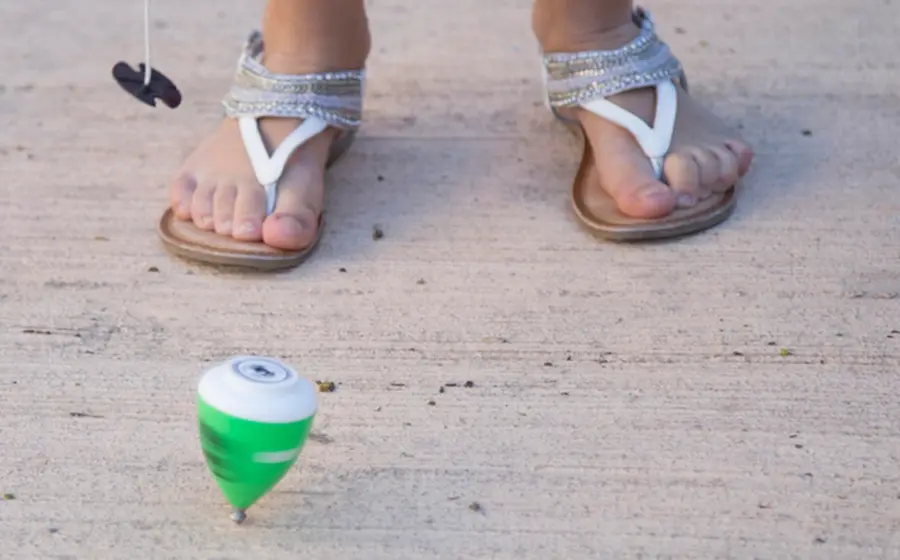 Niña jugando trompo