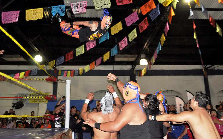 Luchador volando sobre sus oponentes