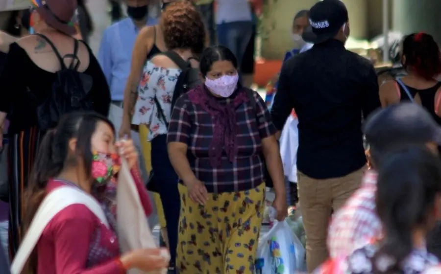 Personas caminando con cubrebocas.