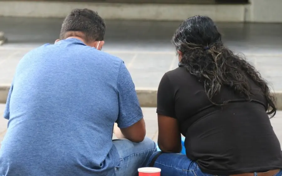 Personas con obesidad sentadas en la calle.