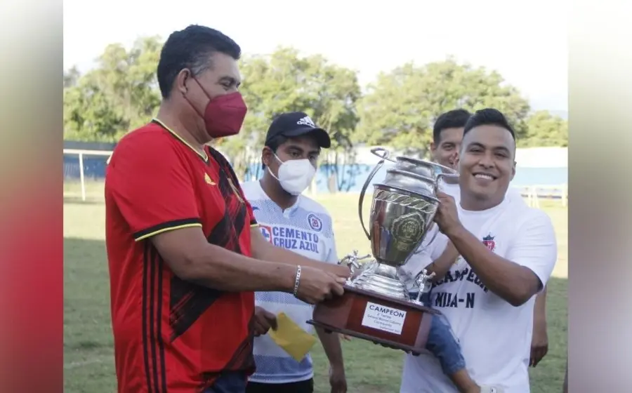 Jugadores sosteniendo trofeo de fultbol