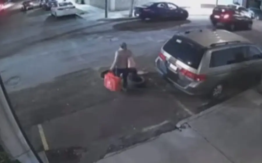 La mujer no se percata que delante de ella hay una coladera sin tapa.