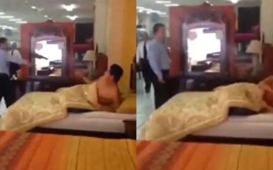 El hombre aparece acurrucado con una cobija y tratando de descansar en una de las camas de una mueblería.