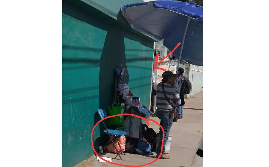 Personas tienen que dejar sus pertenencias a cuidar con un vendedor afuera del IMSS.