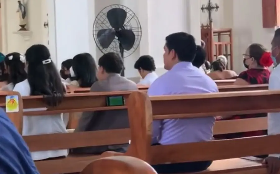 En las imágenes se ve a un hombre en misa viendo en su celular uno de los partidos del mundial.