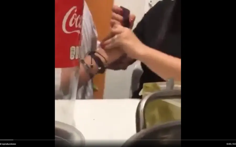 Mujer forcejea con su pareja para que le permita acceder a su teléfono celular.
