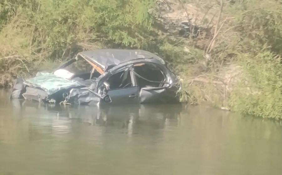 Una camioneta volcada y parcialmente sumergida en una poza de agua tras un accidente fatal que dejó un muerto y tres lesionados.