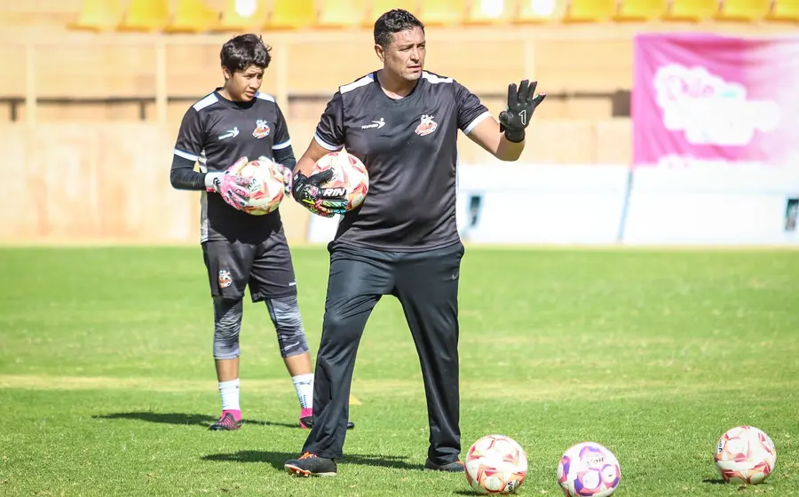 El entrenador Alberto Becerra durante una sesión de entrenamiento con los guardametas del equipo de fútbol Alebrijes, fortaleciendo la portería.