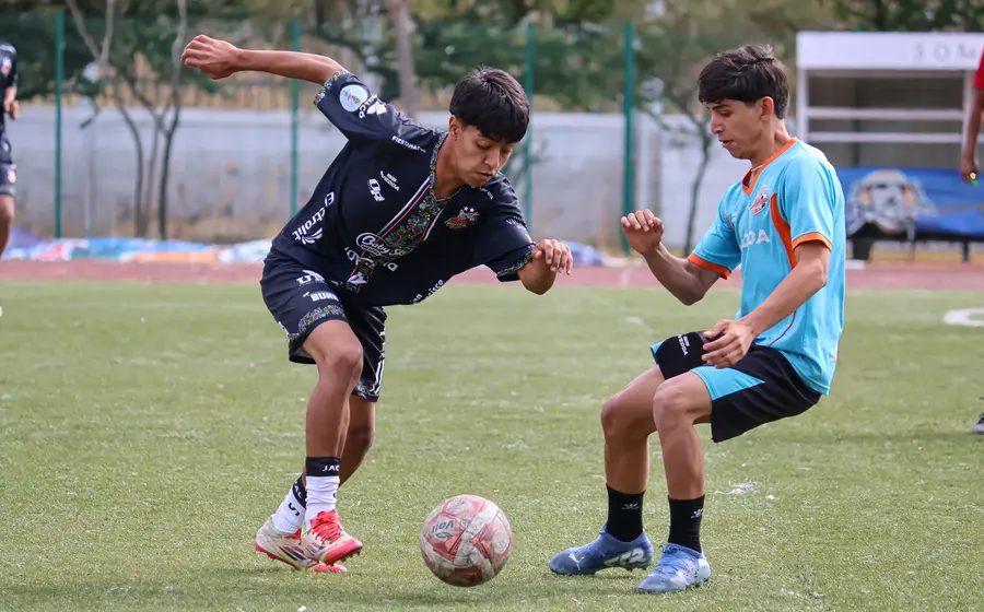 Jóvenes futbolistas compiten en intensos duelos durante el torneo draft del equipo Alebrijes, buscando una oportunidad para mostrar su talento.
