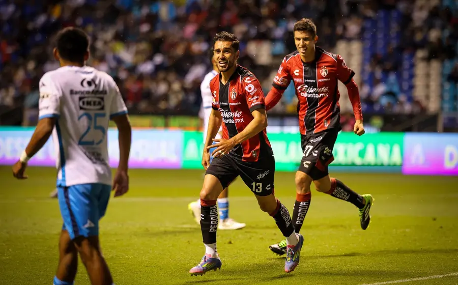 Jugadores de los equipos Atlas y Puebla disputan el balón durante el partido inaugural del torneo de futbol Clausura 2026 de la Liga MX.