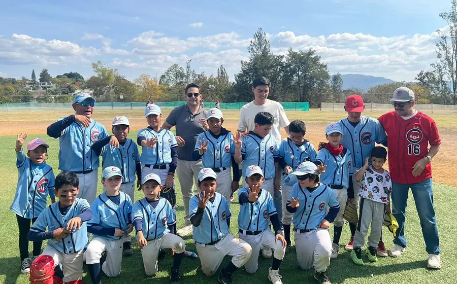 Los jugadores del equipo Cachorros Lma levantan el trofeo de campeones, celebrando con entusiasmo la obtención de otro título para su club.