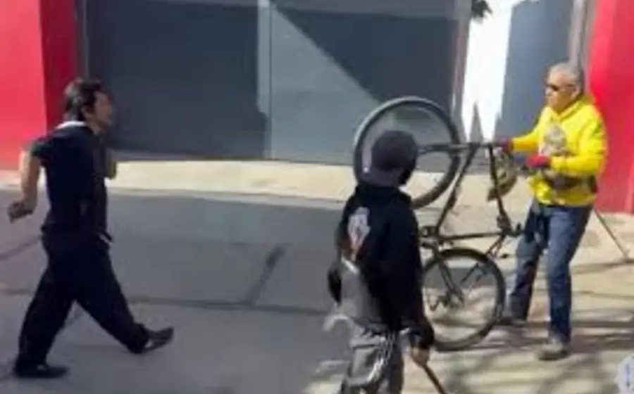 Un chofer levanta un bate de béisbol para golpear a un ciclista en la calle, acto de agresión por el cual perdió su licencia.