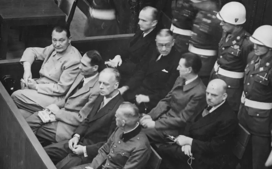 Fotografía histórica en blanco y negro de los dirigentes nazis sentados en el banquillo durante las audiencias de los Juicios de Núremberg.