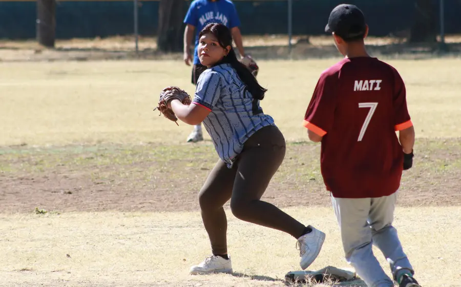 Una jugadora de béisbol del equipo Chivines se mantiene atenta en la segunda base durante un partido celebrado en el diamante.