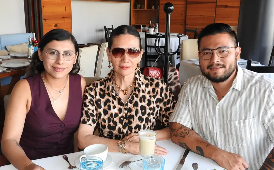 Graciela del Carmen López Aguilar celebra su cumpleaños en Oaxaca, posando sonriente al centro, acompañada por su hijo Andrés y su nuera Andrea.