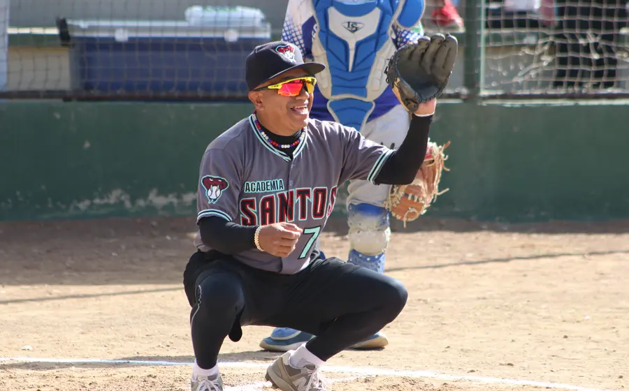 Jugadores del equipo Chivitos se preparan para su tradicional juego de béisbol de fin de año, alistando sus manoplas para el partido.