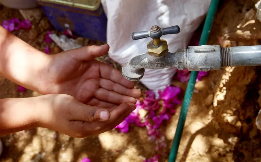 Manos de una persona recibiendo agua potable de un grifo, simbolizando que el consumo humano es prioridad con la nueva Ley de Aguas.