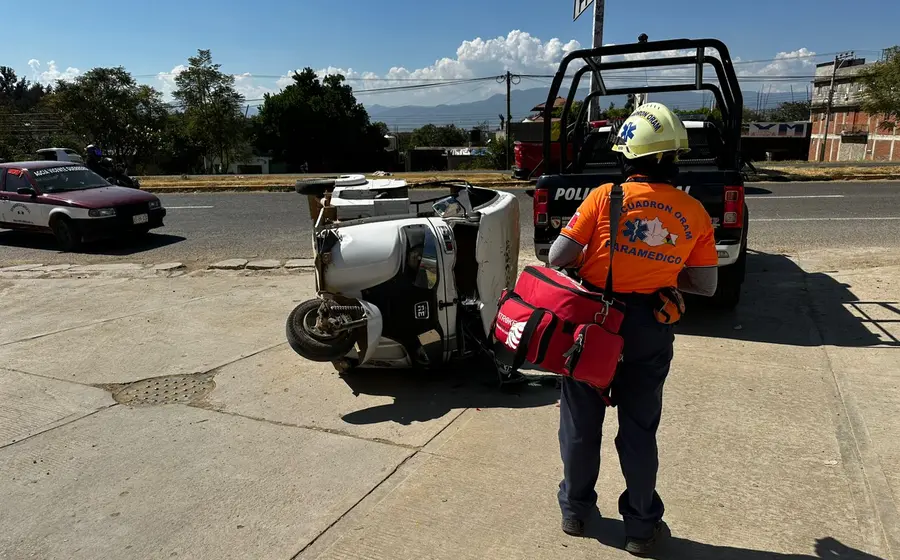 Un mototaxi volcado sobre la carretera federal 175 tras un choque con una patrulla, accidente que dejó a una mujer lesionada.