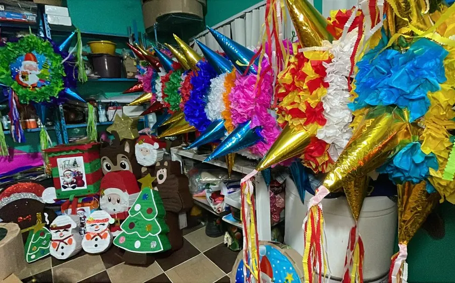 Una colorida variedad de piñatas tradicionales mexicanas colgadas en un puesto, mostrando el aumento de su demanda durante las fiestas de diciembre.