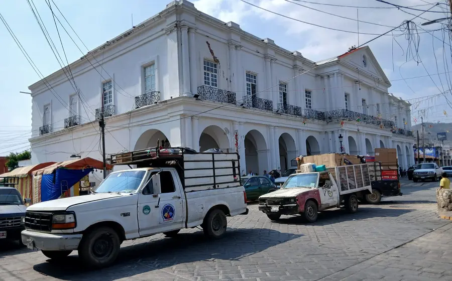 Recolectores de basura utilizan sus camiones para bloquear una calle en Tehuantepec como protesta contra las autoridades municipales por daños a una sepultura.