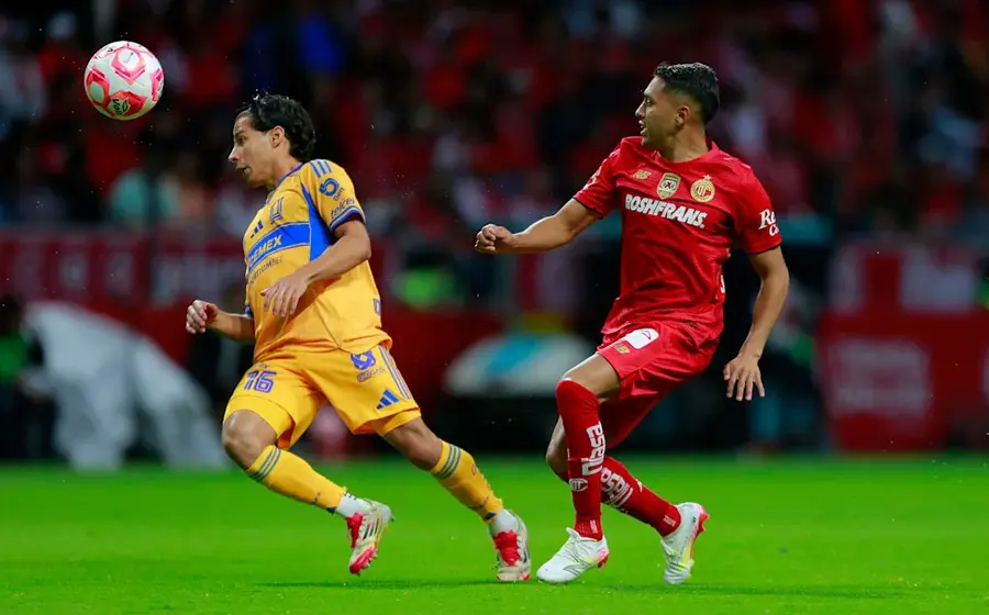 Los equipos de fútbol Tigres y Toluca se enfrentan en la cancha durante el partido de ida de la gran final del torneo.