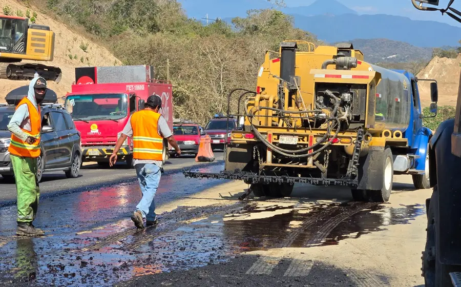 Trabajadores y maquinaria pesada realizando obras de modernización en la carretera federal que conecta a Pochutla con Huatulco, supervisadas por la SICT.