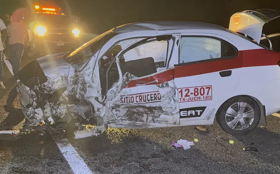 La parte frontal de un taxi, del lado del conductor, se muestra completamente destrozada como resultado de un fuerte accidente vial.