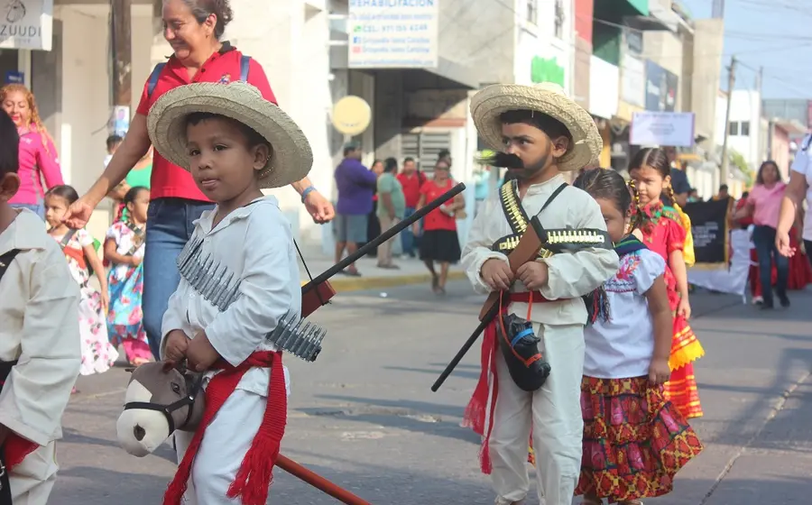 Un grupo de niñas y niños desfilan por la calle caracterizados con trajes de la época revolucionaria para conmemorar el aniversario.