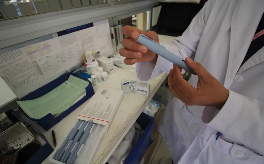 Personal de salud del IMSS realiza una prueba de detección de diabetes a un paciente durante una feria de prevención y salud.