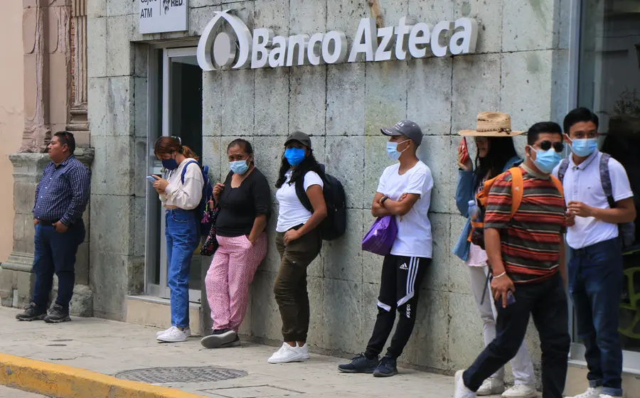 Una persona realiza un pago utilizando billetes de pesos mexicanos, reflejando la preferencia por el efectivo a pesar del avance de la banca digital.