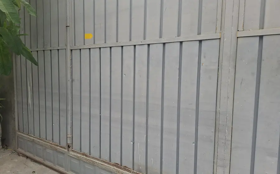 Un portón de metal muestra múltiples impactos de bala tras un ataque armado a una vivienda particular en Juchitán, Oaxaca.
