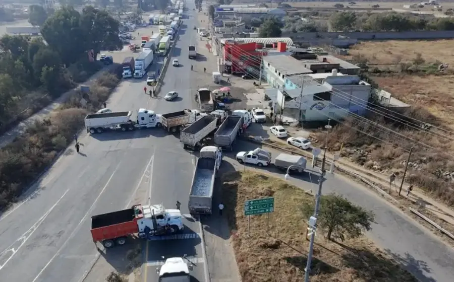 Un grupo de transportistas bloquea una carretera con sus camiones para protestar y exigir al gobierno mayor seguridad ante la crisis de asaltos.