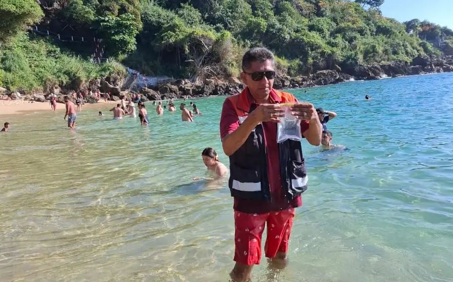 Un especialista toma muestras para las pruebas de calidad del agua en una playa turística de Oaxaca, como Huatulco o Puerto Escondido.