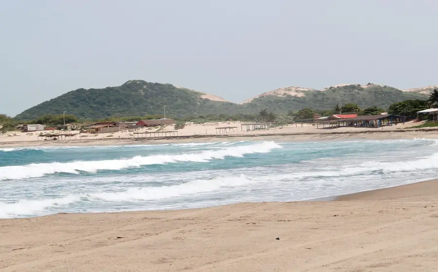 Prestadores de servicios turísticos en una playa concurrida, esperando un repunte económico durante el periodo vacacional de mayor consumo para el sector.