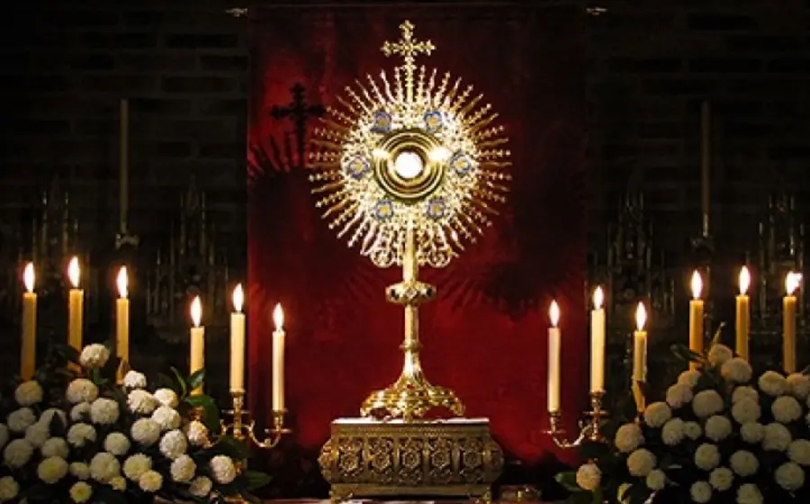 Una persona en actitud de oración durante una visita al Santísimo Sacramento, un momento de reflexión para escuchar a Dios y hacerlo Rey.