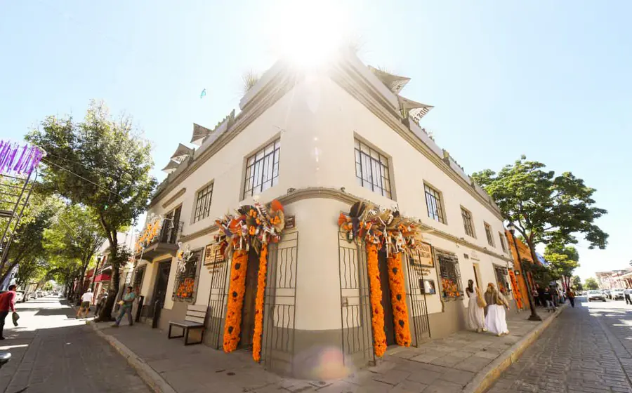 Fachada de una casa decorada de forma colorida y tradicional con flores de cempasúchil para la celebración del Día de Muertos.