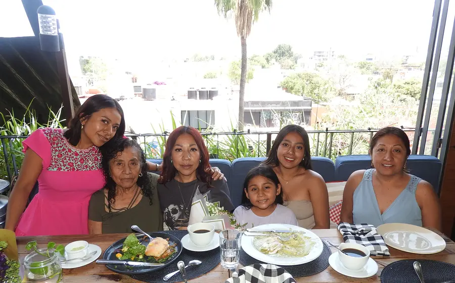 Silvia Ramírez celebra su cumpleaños en una reunión familiar, sonriendo rodeada del cariño de sus hijas, su mamá y su hermana.