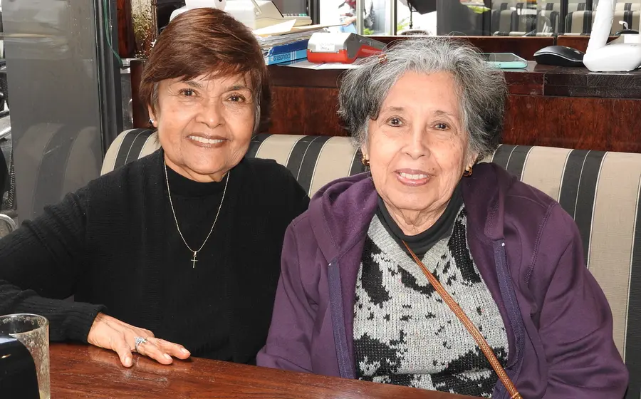 Un grupo de mujeres amigas sonríen y conversan alegremente mientras disfrutan de un desayuno en un ameno encuentro social.
