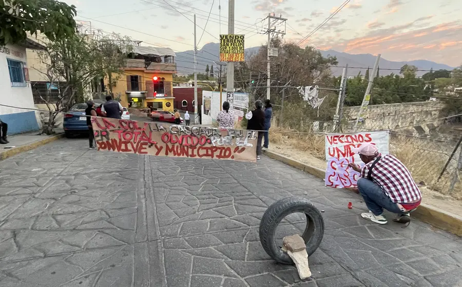 Ciudadanos realizan un bloqueo en una calle de Oaxaca para protestar por la negligencia ante el colapso del sistema de drenaje en La Cascada.
