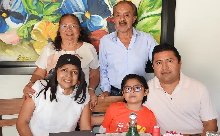 María del Carmen Mendoza, Eliseo González, Ana González, José María y Rubén Reyes sonríen juntos mientras disfrutan de un evento social en Oaxaca.