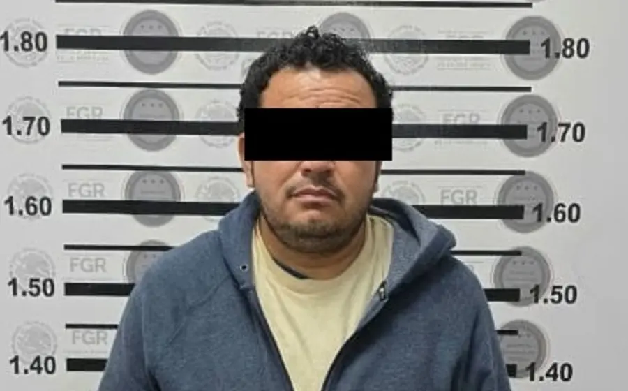 El presunto homicida E. M.S. es entregado por autoridades en Tijuana a elementos de la policía de Oaxaca, quienes lo escoltan.
